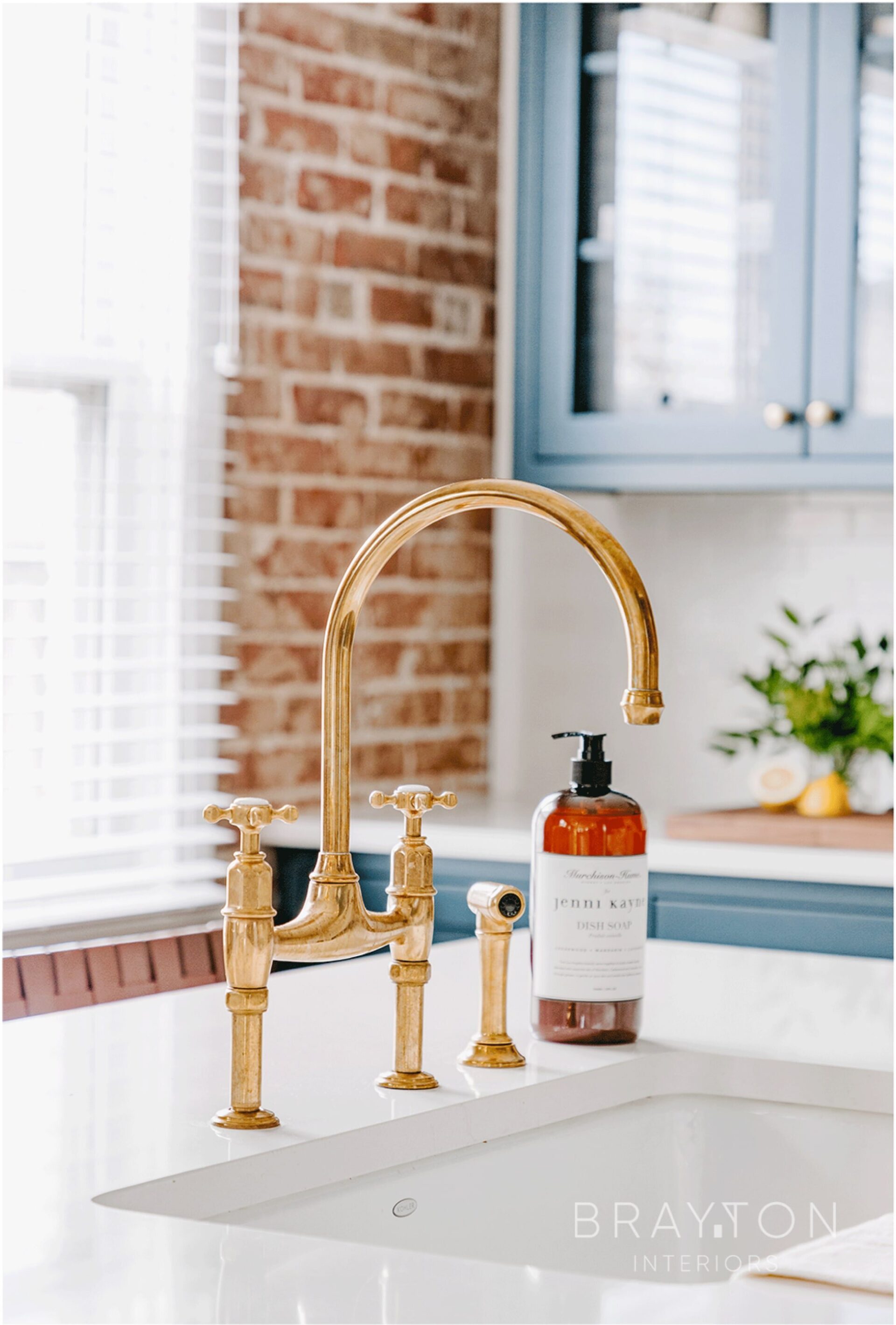 Unlacquered brass faucet from England and a ceramic sink by Kohler in historic Sloan’s Lake bungalow. Lakeside neighborhood in Denver, Colorado, featuring original exposed brick throughout main living area.