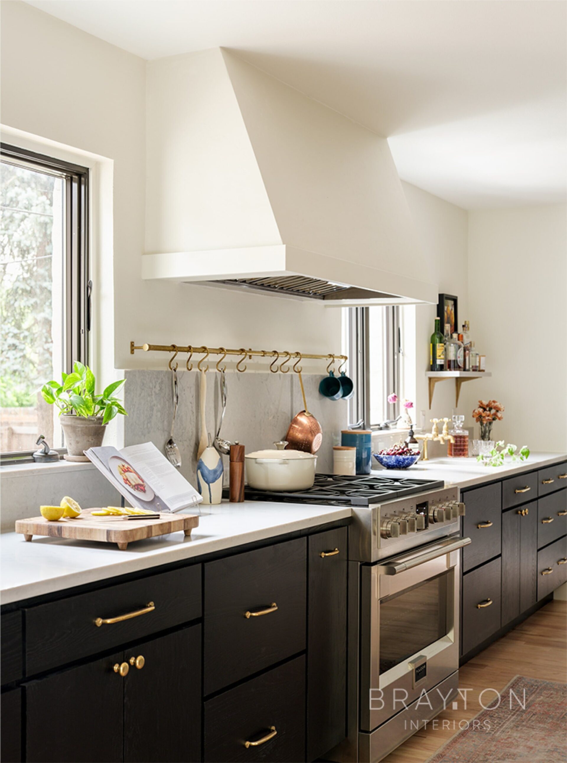 The feature kitchen wall has a custom drywall range hood, an antique brass utensil rod, and a bar sink with an antique brass faucet.