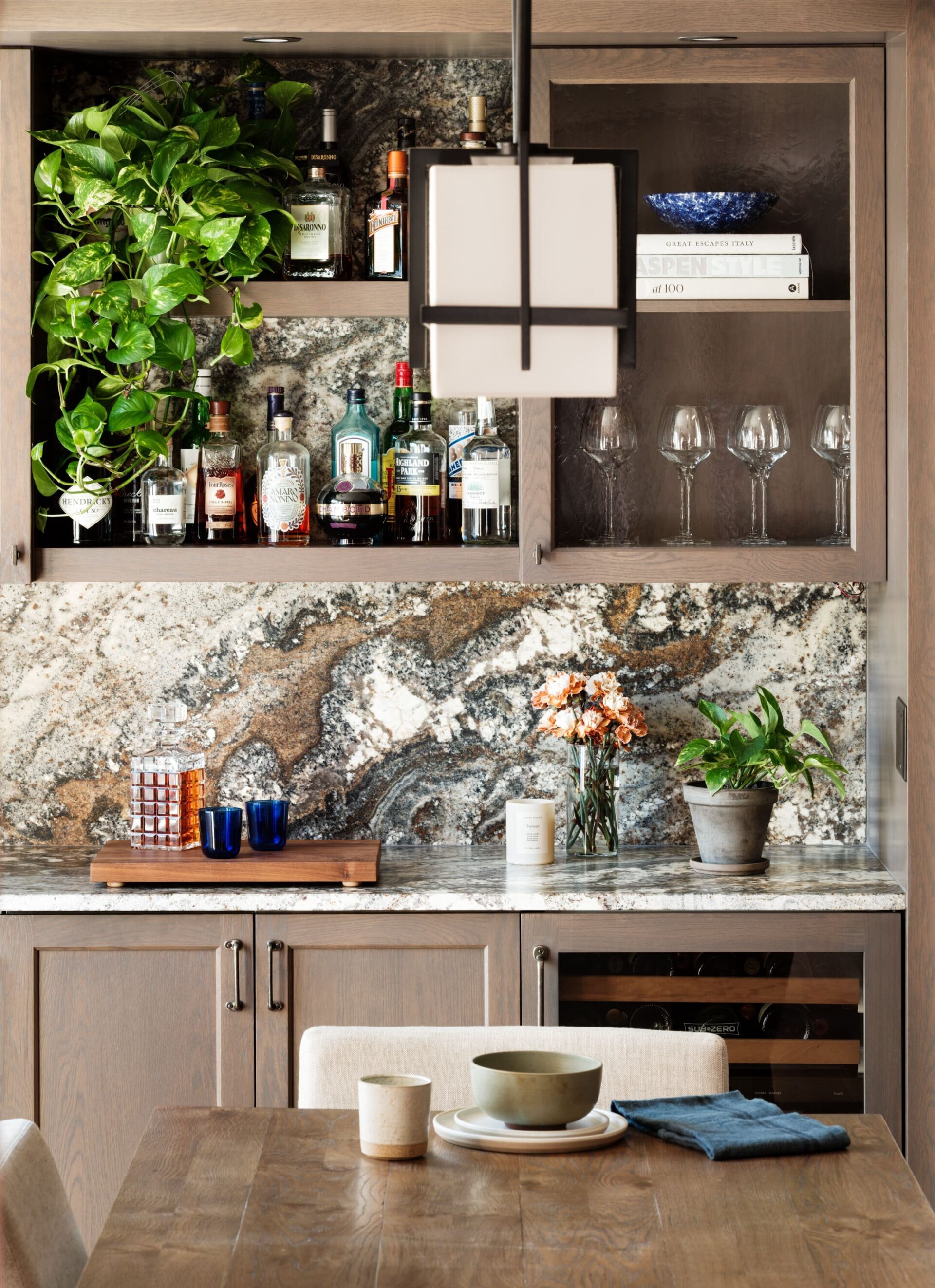 The bar area utilizes custom cabinetry and a marble backsplash